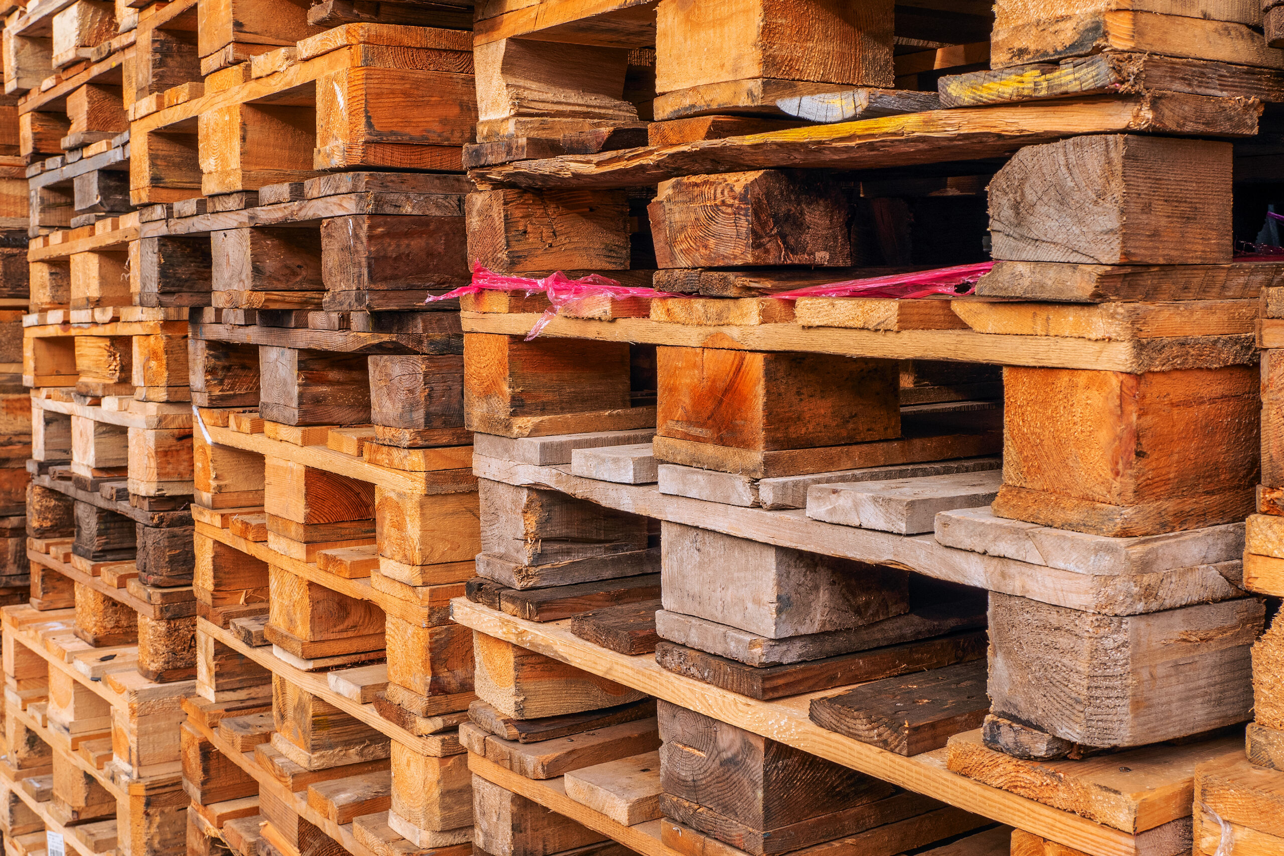 Muchas pilas de palets de madera usados de tipo euro en el almacén.